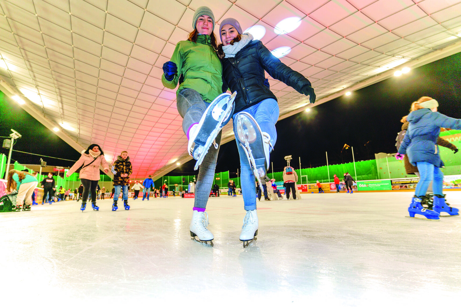Zwei Läuferinnen auf der Eisfläche der Schierker Feuerstein Arena unter dem offenen Hallendach