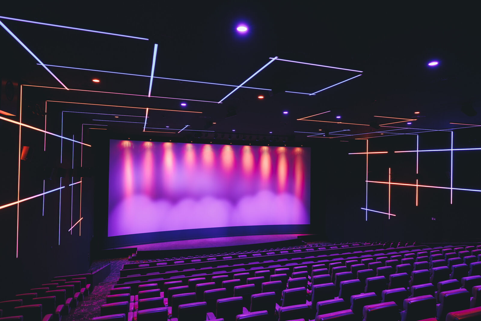 Kinosaal mit Leinwand und Lichtlinien an Wand und Decke