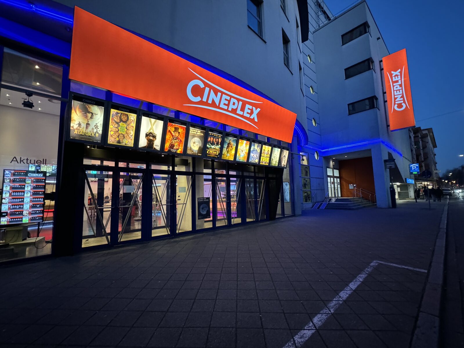 Das Cineplex Mannheim am Abend, die Fassade blau und orange beleuchtet