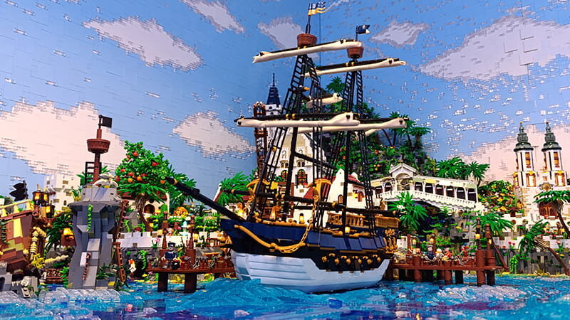 Segelschiff aus Klemmbausteinen in einer Hafenszene