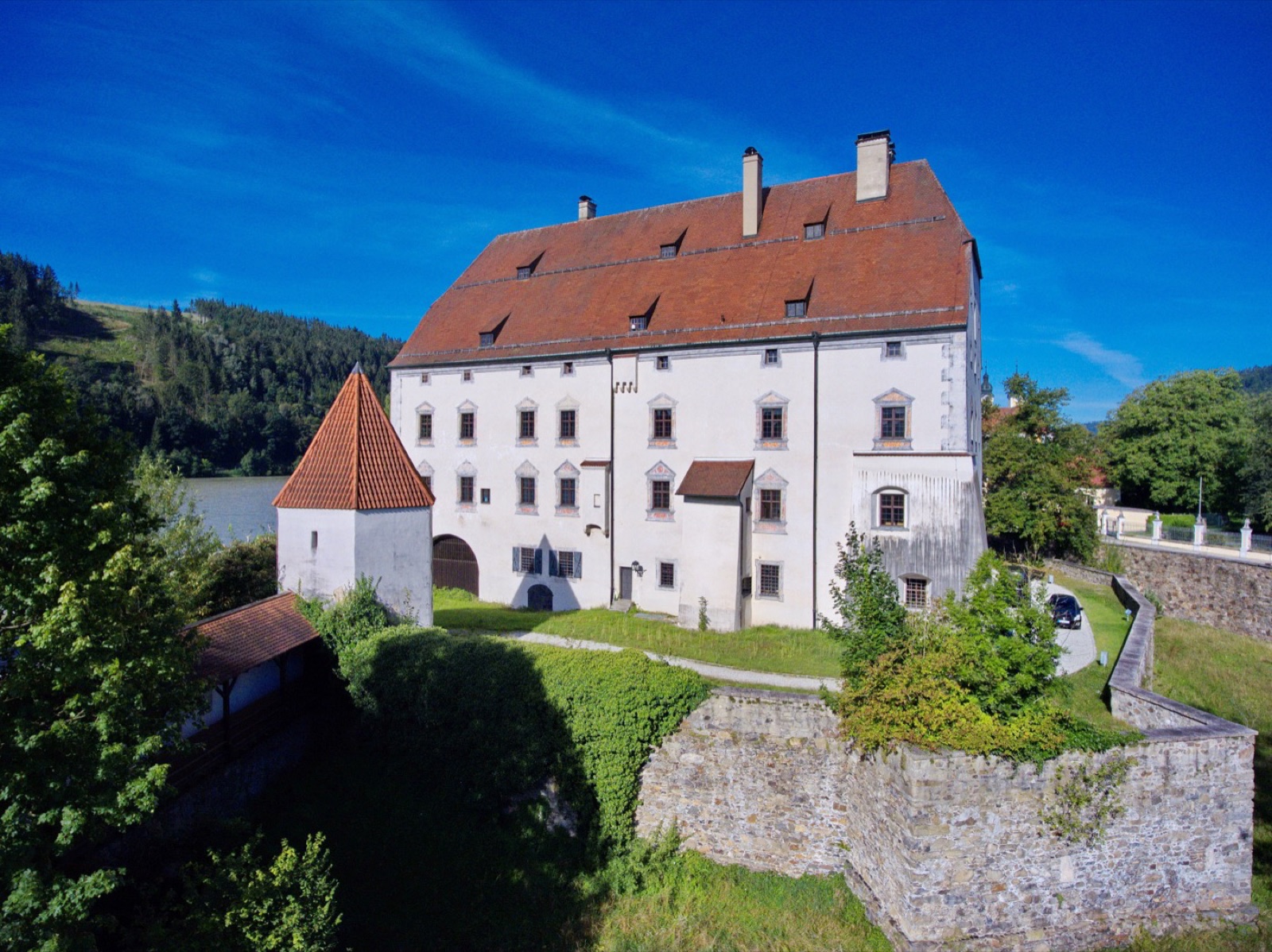 Schloss Obernzell über der Donau, ein weißer Bau mit rotem Ziegeldach und rundem Eckturm