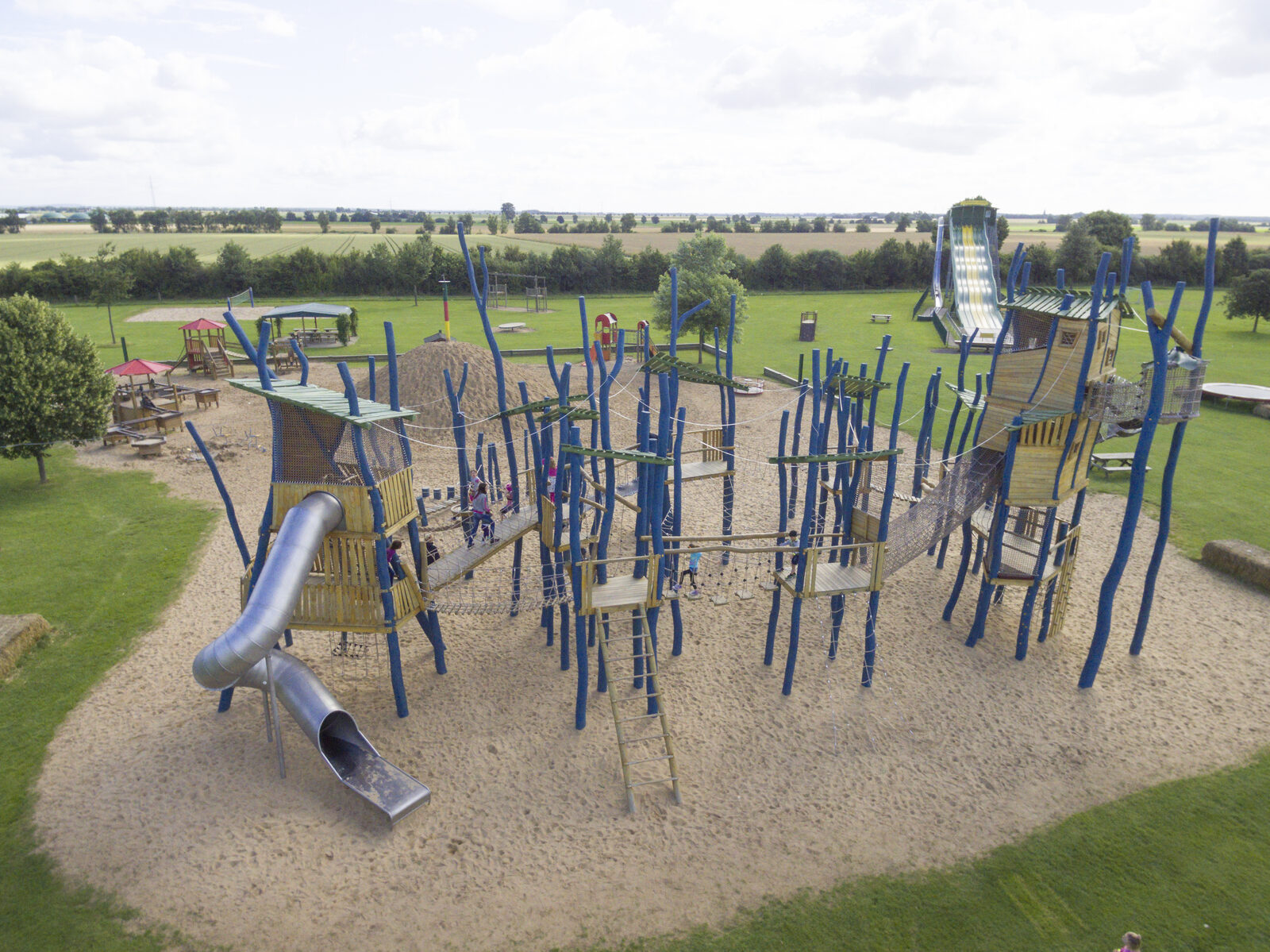 Blick von oben auf den Kletterpark aus blauen Robinienstämmen