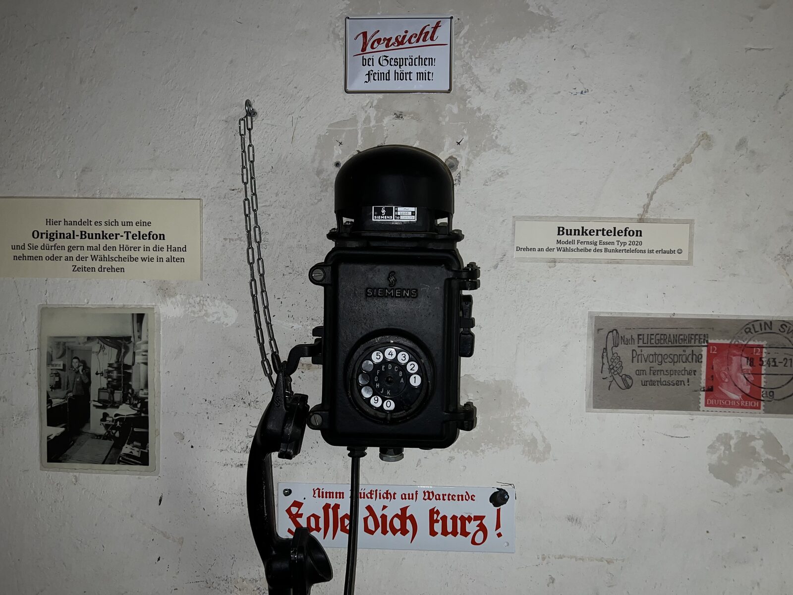 Original-Bunkertelefon von Siemens an der Wand, die Wählscheibe darf gedreht werden