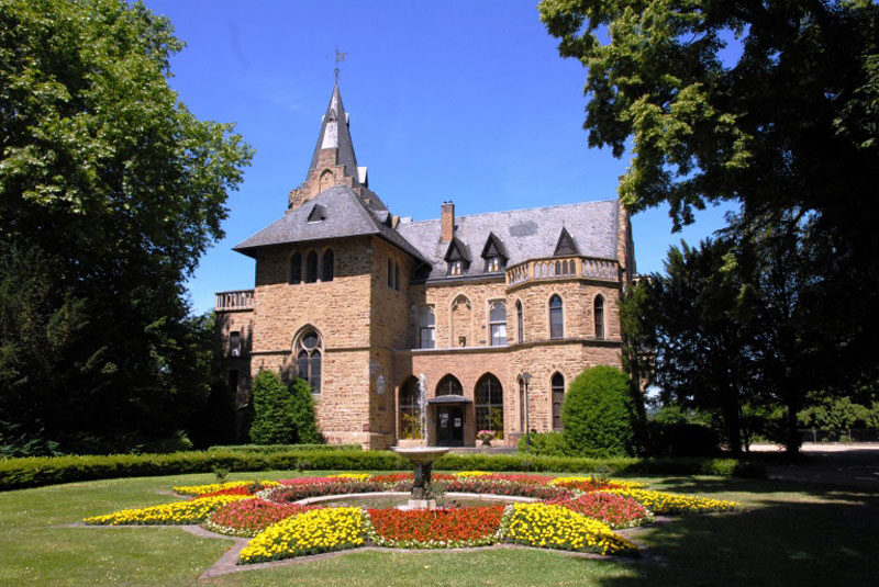 Das neugotische Schloss Sinzig mit Blumenbeet und Springbrunnen
