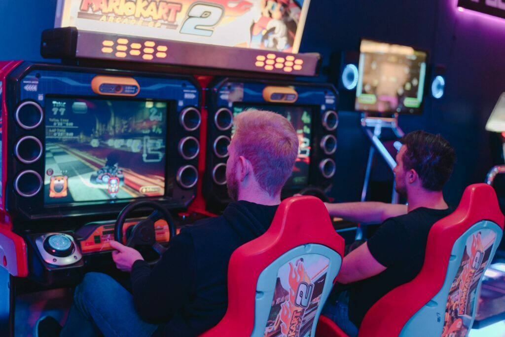 Zwei Rennsitz-Automaten im HI-SCORE mit laufendem Mario-Kart-Spiel, im Neonlicht der Spielhalle