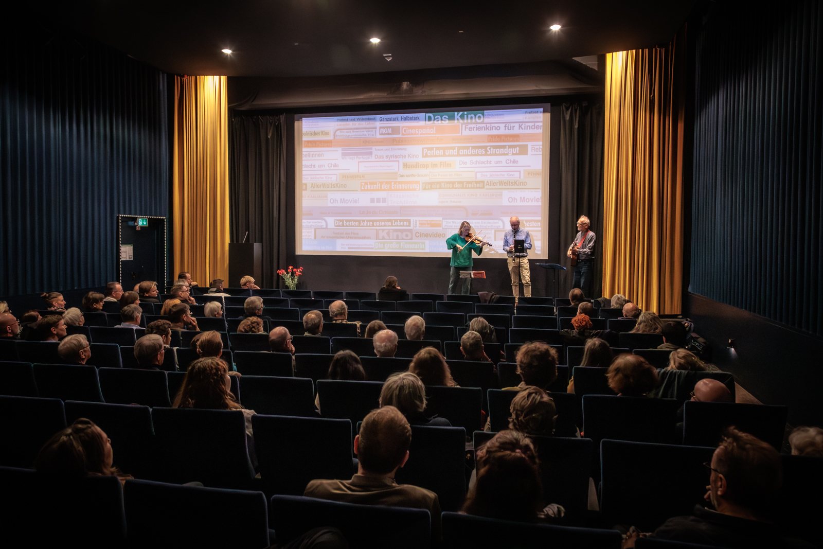 Voll besetzter Saal der Kinemathek Karlsruhe mit Live-Musik vor der Leinwand