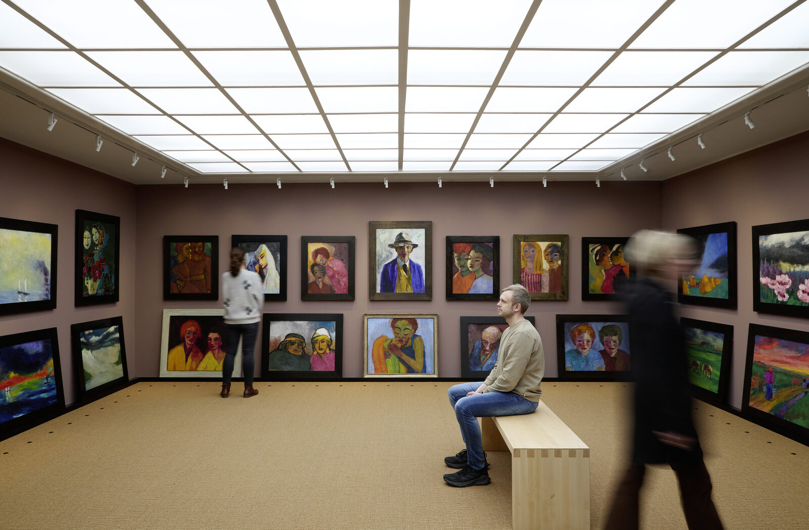 Ausstellungsraum des Nolde Museums Seebüll mit dicht gehängten Gemälden unter einer Lichtdecke