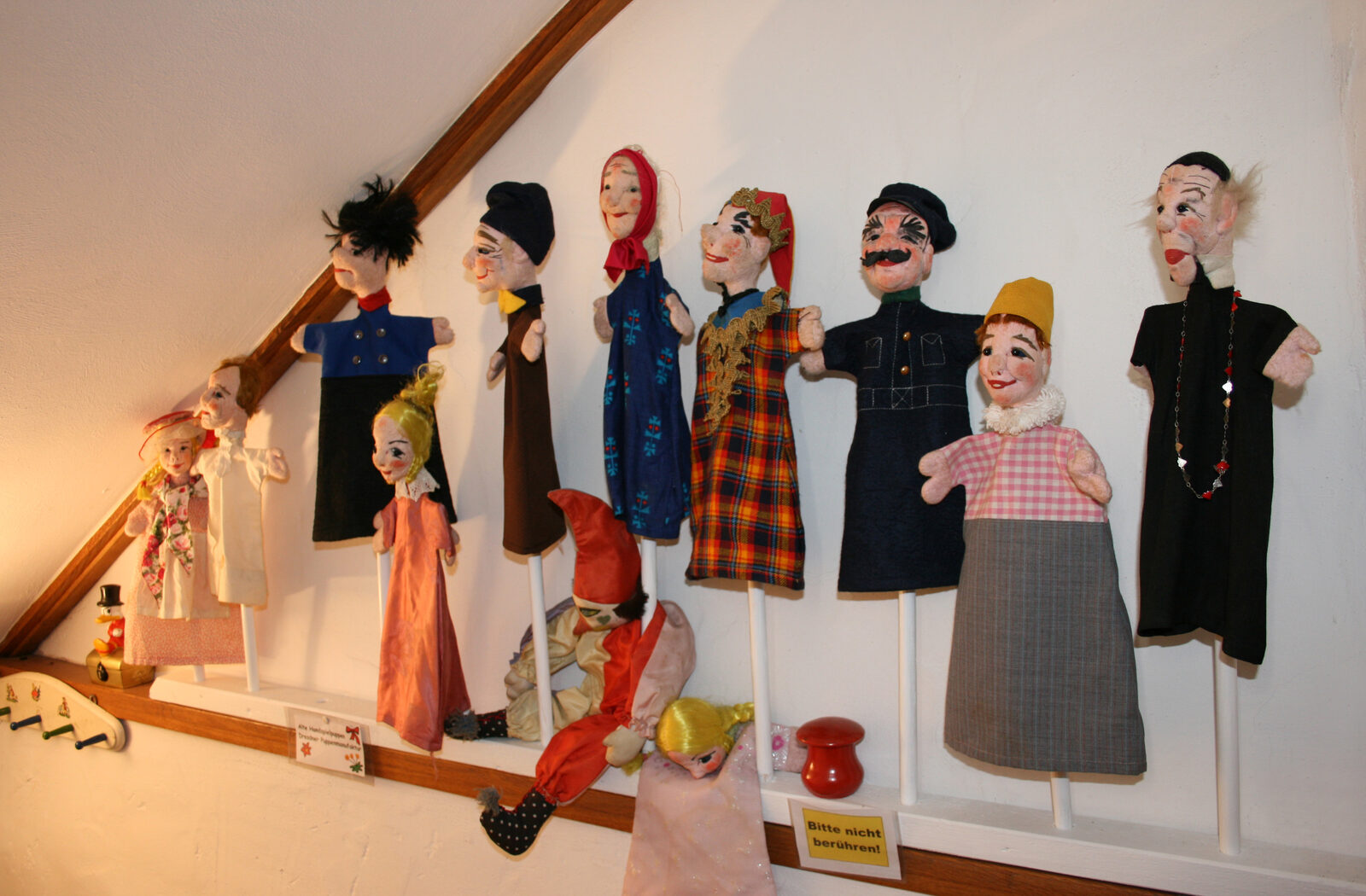 Reihe historischer Handpuppen an der Wand