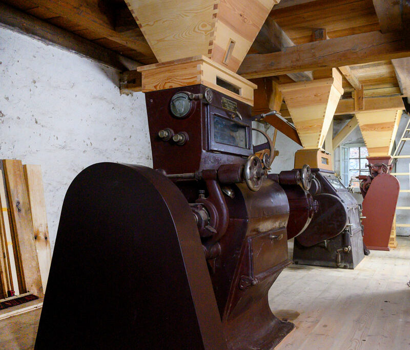 Restaurierte Mühlentechnik unter dem hölzernen Dachstuhl der Wassermühle Ernst Vogel